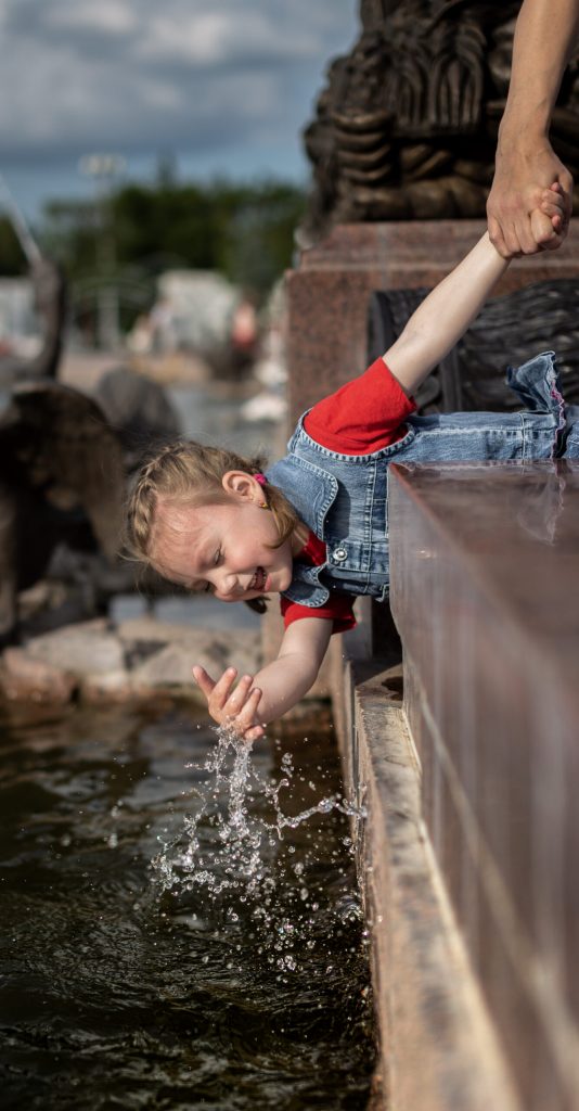 Девочка брызгается водой в фонтане Каменный цветок