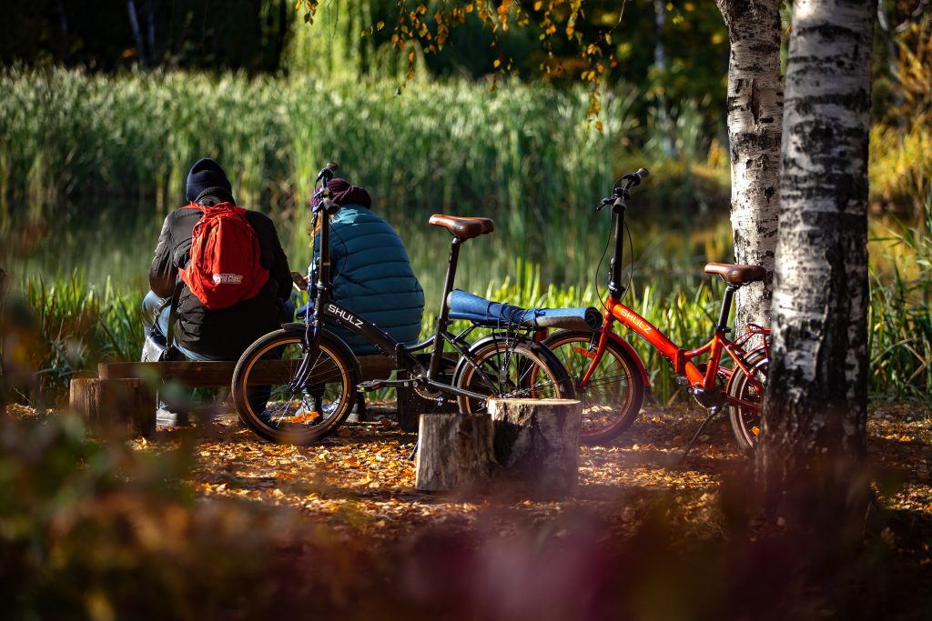 Люди на лавочке рядом с велосипедами в осеннем парке 