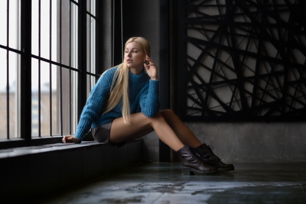 Девушка в синем возле окна в студии