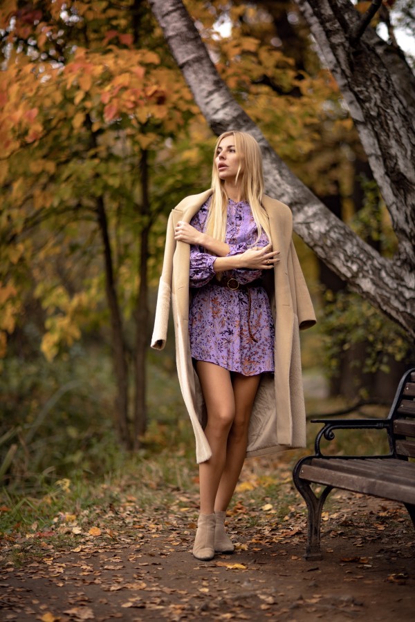 Девушка в бежевом пальто в осеннем пейзаже