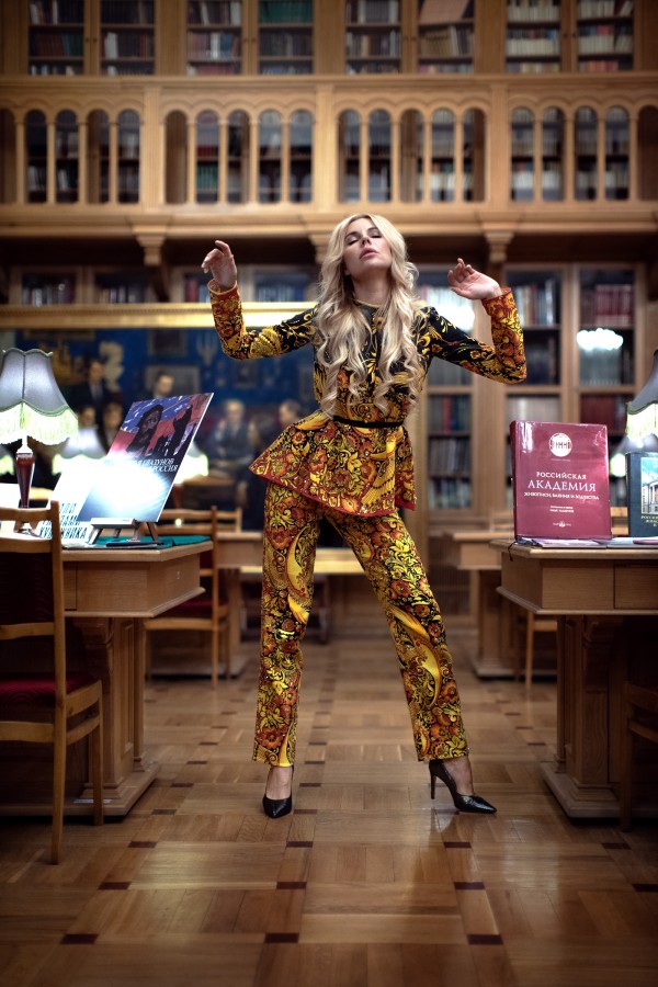 Девушка в ярком костюме танцует в библиотеке