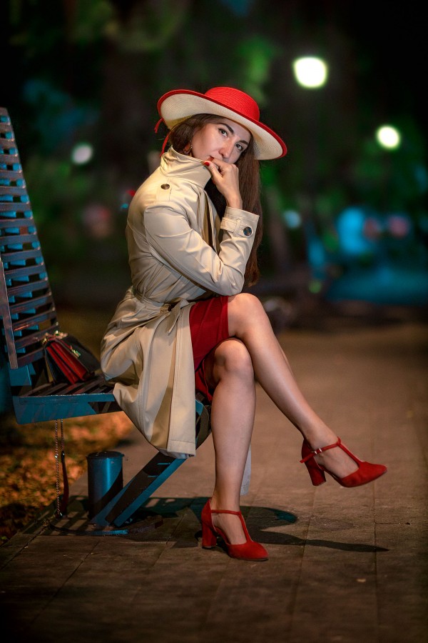 Девушка на лавочке в красной шляпе в вечернем парке
