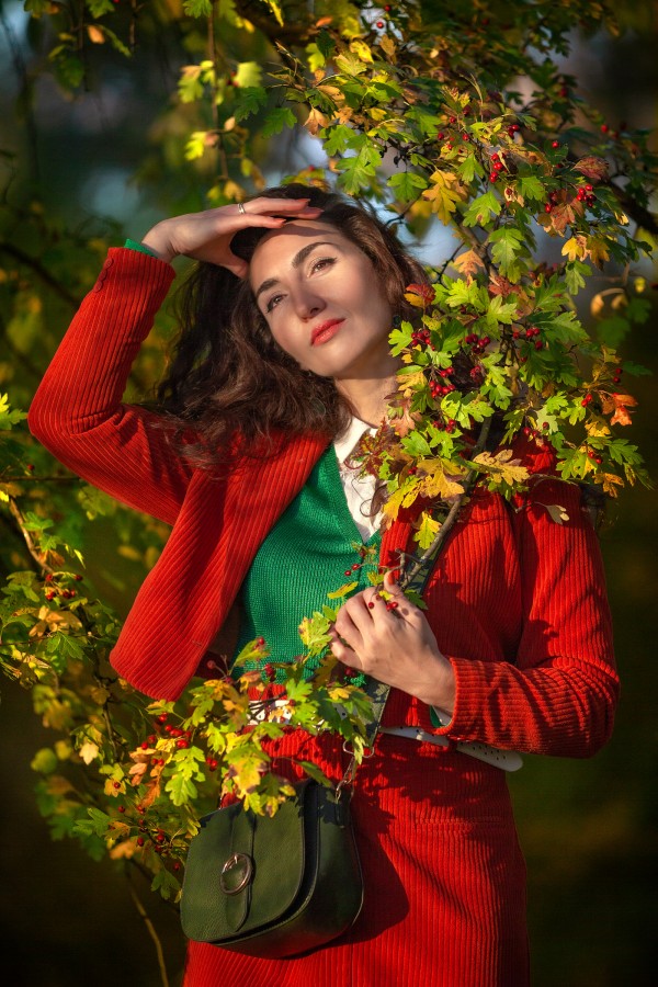 Девушка в красном мечтает в осенней листве