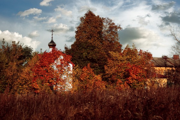 Сельская церковь в красной листве осеннего солнца